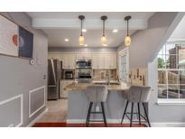 Well-lit kitchen features granite countertops, stainless steel appliances, and bar seating with decorative pendant lights at 8360 W 87Th Dr # D, Arvada, CO 80005