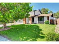 Charming home featuring a lush front lawn and inviting curb appeal with mature shade tree at 3621 S Kalispell St, Aurora, CO 80013
