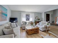 Bright living room featuring hardwood floors, large window with natural light, and comfortable seating arrangement at 3621 S Kalispell St, Aurora, CO 80013