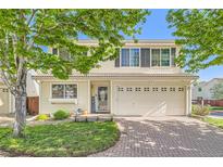 Charming two-story home featuring a brick driveway, a two-car garage and neutral toned siding at 20000 Mitchell Pl # 51, Denver, CO 80249