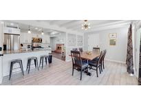 Bright and open kitchen and dining area with wood floors and stainless steel appliances at 3067 S Holly Pl, Denver, CO 80222
