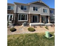 A charming townhome featuring stone accents and a well-manicured lawn at 14883 E Crestridge Dr, Centennial, CO 80015