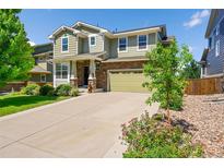Charming two-story home with a well-manicured lawn, a long driveway, and a two-car garage at 5722 S Flat Rock Way, Aurora, CO 80016