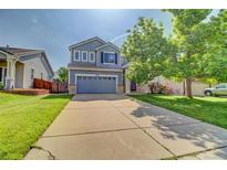 Charming two-story home featuring a spacious driveway, attached two-car garage, and well-manicured lawn at 8416 S Reed St, Littleton, CO 80128