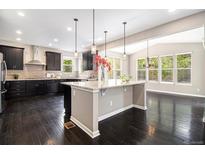 Spacious kitchen featuring dark cabinetry, pendant lighting, and large center island at 3522 Harvard Pl, Broomfield, CO 80023