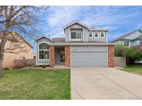 Charming two-story home with a well-manicured lawn, complemented by a two-car garage and tasteful brick accents at 1544 E Weldona Way, Superior, CO 80027