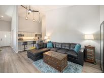 Stylish living room with high ceilings, a large black leather sofa, and open access to the kitchen at 2279 E 129Th Ave, Thornton, CO 80241