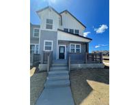 Charming two-story home with light blue and white siding, a cozy porch, and newly installed front yard at 6562 Arbor Blvd # 1, Thornton, CO 80602