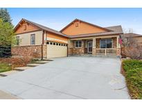 Charming home with stone accents, front porch, attached garage, and driveway at 2958 S Lisbon Way, Aurora, CO 80013