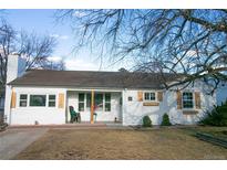 Charming single-story home featuring a white brick facade, complemented by wooden shutters and a well-maintained front yard at 3040 S Clermont Dr, Denver, CO 80222