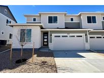 Two-story home featuring a two-car garage, gray siding, and a well-manicured lawn with young tree at 6595 N Nepal St, Aurora, CO 80019