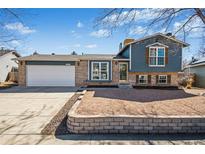 Charming bi-level home featuring brick and blue siding, complemented by a well-maintained front yard at 8622 S Everett St, Littleton, CO 80128