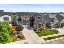 Beautiful two-story home boasting a large driveway, well-manicured lawn, and attractive stone and stucco facade at 15033 Delhi Ave, Parker, CO 80134