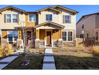 Charming two-story townhome with a welcoming front porch and well-maintained landscaping at 13725 Ash Cir, Thornton, CO 80602