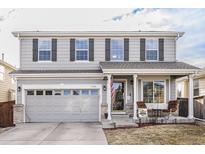 Charming two-story home with gray siding, black shutters, a two-car garage, and a cozy front porch at 11866 High Desert Rd, Parker, CO 80134