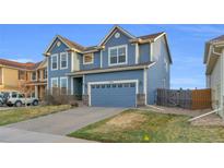 Beautiful two-story home featuring a blue exterior, well-manicured lawn, and attached two-car garage at 17216 E Trailmaster Dr, Parker, CO 80134