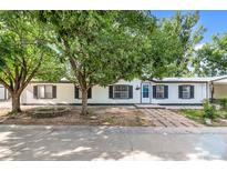 Charming single-story home with a well-maintained lawn and mature trees at 5325 Allison St, Arvada, CO 80002