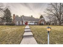 Charming brick home with well-manicured lawn, red front door, and inviting front porch at 2501 S Gray Ct, Lakewood, CO 80227