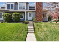Inviting townhouse featuring a well-maintained lawn, charming facade, and brick chimney at 8220 W 90Th Pl # 2003, Broomfield, CO 80021