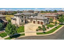 Stunning two-story home showcasing a three-car garage, well-manicured lawn, and charming stone accents at 8017 S Valleyhead Way, Aurora, CO 80016