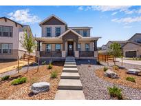 Charming two-story home with inviting front porch and professionally landscaped front yard at 3318 N Haleyville Ct, Aurora, CO 80019