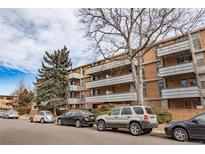 Brick apartment building featuring multiple balconies, mature trees, and convenient street parking at 2500 S York St # 213, Denver, CO 80210