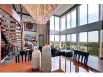 Elegant living room featuring spiral staircase, chandelier, floor-to-ceiling windows, and stunning views at 1900 E Girard Pl # 901, Englewood, CO 80113