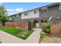 Charming townhome featuring a fenced front yard, brick accents, and welcoming entrance at 8075 Wolff St # K, Westminster, CO 80031