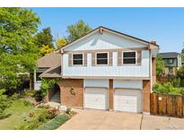 Charming two-story home with a brick facade, two-car garage, and beautifully landscaped front yard with colorful flowers at 3907 E 133Rd Ct, Thornton, CO 80241