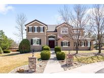 Beautiful two-story home featuring a landscaped front yard, walkway, and stylish architectural details at 8390 Coyote Dr, Castle Pines, CO 80108