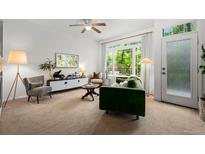 Bright living room featuring a comfortable green sofa, large windows, and modern furnishings at 9300 E Florida Ave # 1202, Denver, CO 80247
