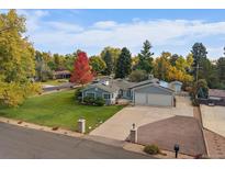 Charming single Gathering home featuring an attached two car garage and lush front lawn at 34 Skyline Dr, Wheat Ridge, CO 80215