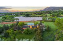Stunning aerial view of estate, nestled on sprawling grounds with a private lake and mountain backdrop at 700 Utica Ave, Boulder, CO 80304