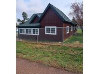 Charming single-story home featuring a dark green roof and neatly fenced yard at 245 Lower Glenway St, Palmer Lake, CO 80133