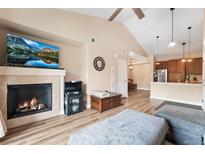 Cozy living room features a fireplace, high ceilings, and open access to the kitchen at 8779 S Kipling Way # 204, Littleton, CO 80127