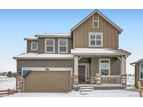 Two-story house with brown siding, a double garage, and a front porch at 250 Paloma Way, Elizabeth, CO 80107