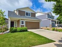 Charming two-story home with a well-manicured lawn and attached two-car garage at 20768 Randolph Pl, Denver, CO 80249
