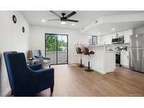Bright living room featuring modern finishes, a breakfast bar, and sliding door access to the outside at 8701 Huron St # 2-106, Thornton, CO 80260