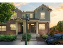 Inviting two-story townhome with brick and stucco exterior under a beautiful sunset at 701 N Roslyn St # 36, Denver, CO 80230