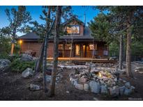 Charming log home featuring a welcoming front porch and a beautifully landscaped yard with natural rock features at 44 Linn Ln, Golden, CO 80403