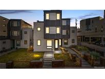 Modern home boasts a unique facade, a well-kept lawn, and landscaped garden beds at 1930 W 35Th Ave, Denver, CO 80211