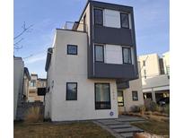 Modern home with a combination of gray and white finishes and an appealing rooftop deck on a sunny day at 1930 W 35Th Ave, Denver, CO 80211