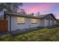 Nice home with white brick, manicured lawn, and a great sunset backdrop at 5780 W 5Th Ave, Lakewood, CO 80226