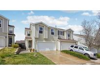 Two-story home with white siding, attached garages, and manicured lawn at 21961 E Crestline Pl, Aurora, CO 80015