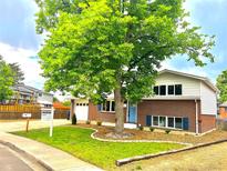 Charming brick home with a well-manicured lawn and inviting blue front door at 1011 Yeager Dr, Longmont, CO 80501