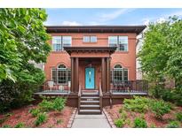 Charming two-story home with a well-manicured front yard and a welcoming porch with seating at 8728 E 25Th Dr, Denver, CO 80238