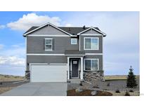 Charming two-story home with gray siding, stone accents, a two-car garage, and professionally landscaped front yard at 43124 Kawana Gulch St, Elizabeth, CO 80107