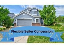 Charming two-story home with a well-maintained lawn, a two car garage and colorful front yard landscaping at 2295 Sandhurst Dr, Castle Rock, CO 80104