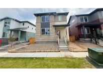 Charming two-story home featuring stone accents and a well-manicured lawn at 21152 E 63Rd Dr, Aurora, CO 80019