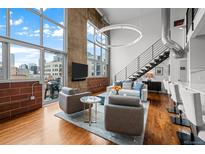 Bright living room features hardwood floors, large windows, and modern decor at 1050 Cherokee St # 403, Denver, CO 80204